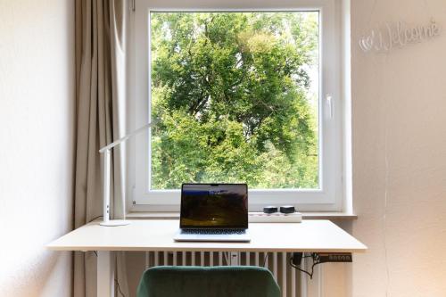 a laptop sitting on a desk in front of a window at Apartment Basilikablick I 3 Zimmer Wohnung mit Küche und Bad in Weingarten