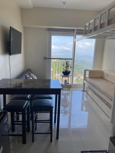 a dining room with a table and chairs and a balcony at Balay Nuevo in Kaybagal