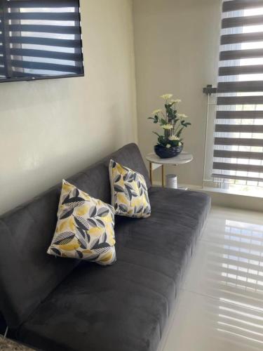 a couch with two pillows on it in a living room at Balay Nuevo in Kaybagal