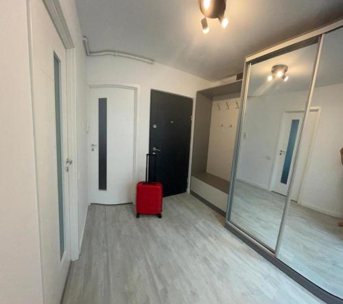 a room with a red suitcase and a mirror at Mangalia Cozy Suite in Mangalia