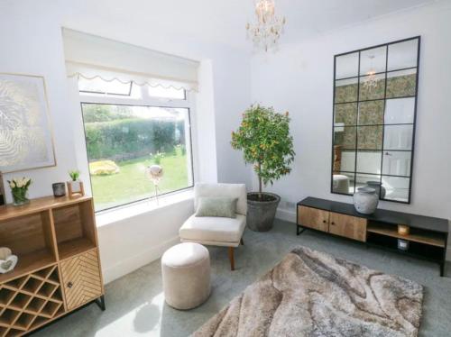 a living room with a chair and a window at Burry House North Gower in Llanmorlais