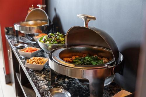 a buffet with several pots of food on a counter at Hilton Garden Inn Downtown Dallas in Dallas