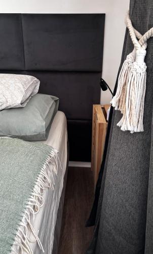a bedroom with a bed and a black headboard at Remote Work Friendly Zahradní apartmán u jezera in Staré Splavy