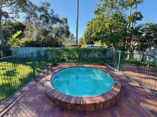 a small pool with a wooden circle in a backyard at Cheerful 5 Bedroom Holiday Destination in Browns Plains