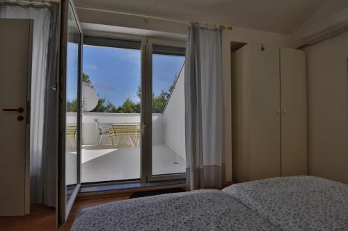 a bedroom with a bed and a view of a balcony at Villa A in Pirovac