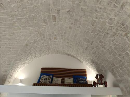 a room with a stone ceiling and a shelf with books at La casa di Laura in Ostuni