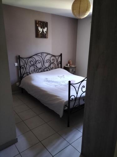 Un dormitorio con una cama grande con sábanas blancas. en L infiniment zen, en Caromb