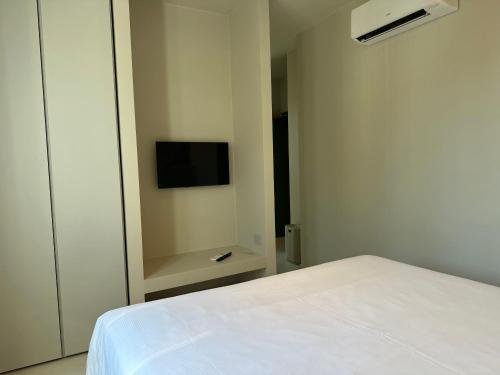 a bedroom with a white bed and a tv at Hotel San Michele in Celle Ligure