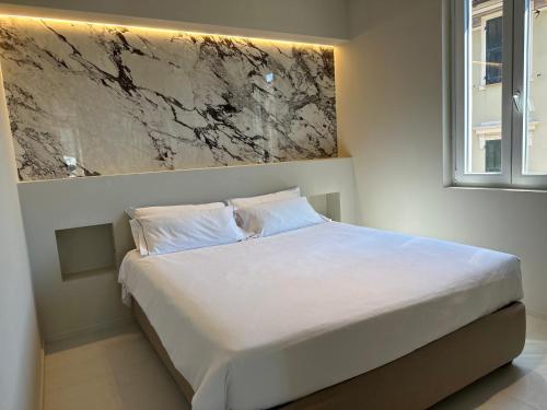 a bedroom with a white bed with a painting on the wall at Hotel San Michele in Celle Ligure