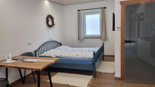 a bedroom with a bed and a table and a window at Biohof Abraham - Hofkäserei in Gossenreith