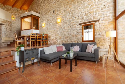 Espacioso pajar con chimenea y BBQ en el Matarraña في Lledó: غرفة معيشة بها أريكة وطاولة