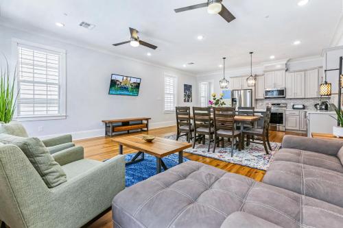 ニューオーリンズにあるHosteeva Stunning 4 BR Condo w Pool Steps to St Charles Aveのソファとテーブルのあるリビングルーム