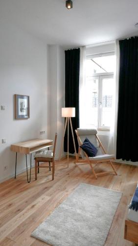 a living room with a table and a desk at klein & fein Gästehaus in Schwelm