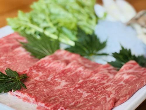 a plate of meat and vegetables on a table at Matsunoki-tei in Otari