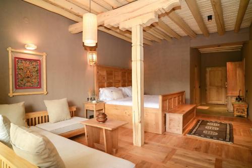 a bedroom with a bed and a couch at Bilupa Mountain Lodge in Shūshot