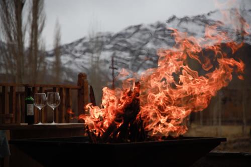a fire in a pot with glasses of wine at Bilupa Mountain Lodge in Shūshot