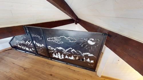 an attic room with a black and white painting on a wall at Pagotin de charme à Métabief in Métabief