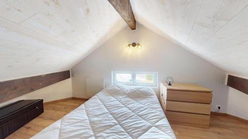 a bedroom with a bed and a dresser in a attic at Pagotin de charme à Métabief in Métabief