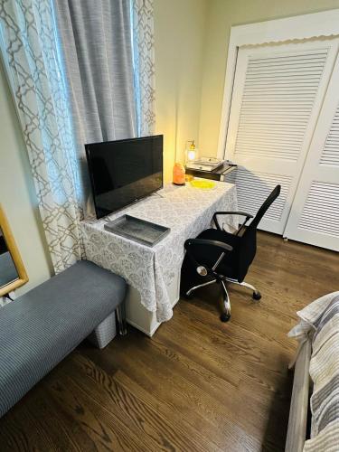 a room with a table with a television and a chair at The Peaceful Perch Retreat Near NYC Elle's Home in Trenton