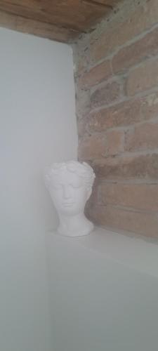 a white toilet in a room with a brick wall at B&B La Loggia in Lonato del Garda