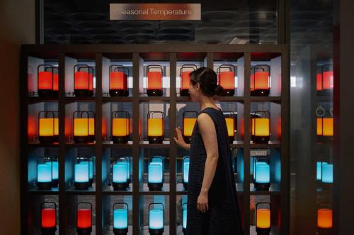 a woman looking at a display of wine bottles at Ondo Hotel and Spa Jongno by Aank in Seoul