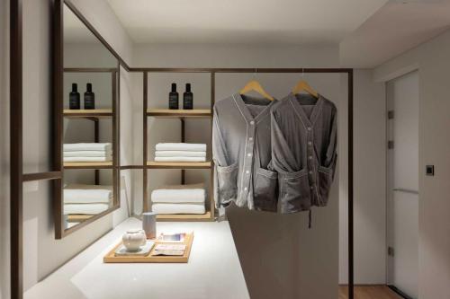 a room with a jacket hanging on a rack at Ondo Hotel and Spa Jongno by Aank in Seoul