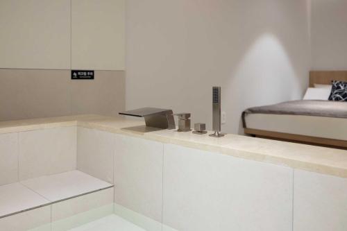 a white room with a bed and a counter with at Ondo Hotel and Spa Jongno by Aank in Seoul