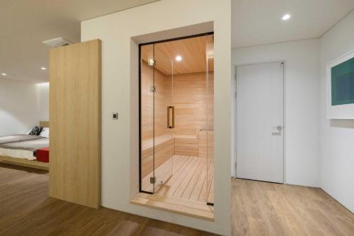 a bathroom with a walk in shower next to a bed at Ondo Hotel and Spa Jongno by Aank in Seoul