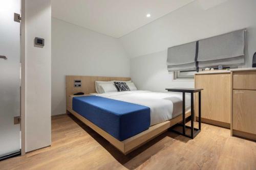a bedroom with a large bed and a table at Ondo Hotel and Spa Jongno by Aank in Seoul