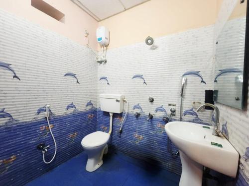 a bathroom with a toilet and a sink at Resort Garden Retreat Seaview in Mandarmoni