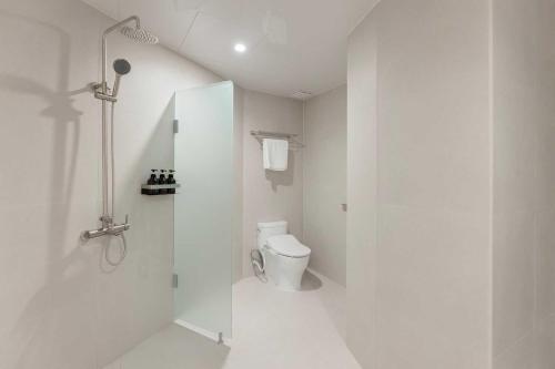 a white bathroom with a toilet and a shower at Ondo Hotel and Spa Jongno by Aank in Seoul