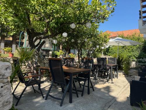 a table and chairs sitting under a tree at Pythaïs Hotel in Pythagoreio