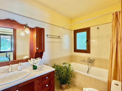 a bathroom with a tub and a sink and a tub and a mirror at Beachfront Villa Calypso with private pool by DadoVillas in Acharavi