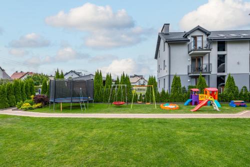 a playground in a yard with a house at Komfort i spokój blisko natury - Apartamenty i pokoje ARKO in Ostrowo
