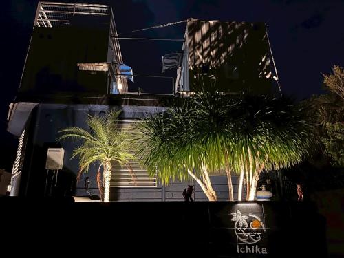 a group of palm trees in front of a building at 最大18名OK 南城市 百名の大型貸別荘 BBQ ビーチ近くでグループ滞在に最適 Seaside House Ichika in Nanjo
