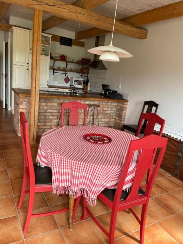 a dining room table with red chairs and a red and white checkered table at Lyckås Gårds Gästboende in Höganäs