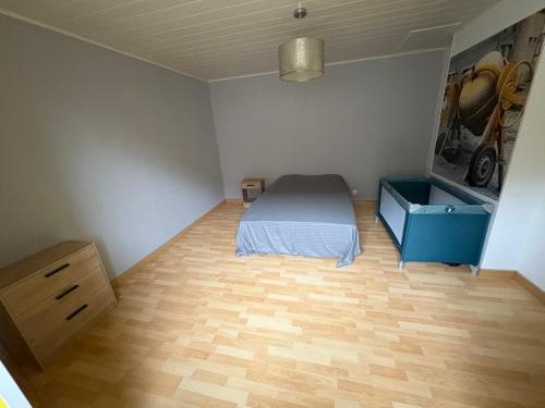 a bedroom with a bed and a dresser in it at Le Champ du Bonheur in Esprels