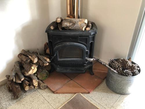a black stove in a corner with a trash can at Retreat Centre Cyprus in Zoopiyi