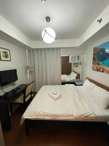 um quarto com uma cama, uma secretária e um computador em Antel Spa Residences 1908 em Manilla