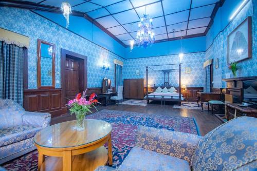 a living room with blue tiled walls and a table at Balrampur House Heritage Hotel in Nainital