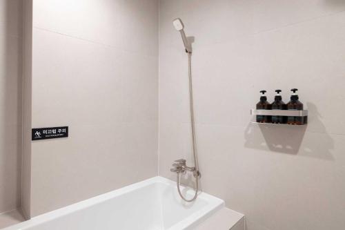 a bathroom with a shower with bottles of wine at Ondo Hotel and Spa Jongno by Aank in Seoul