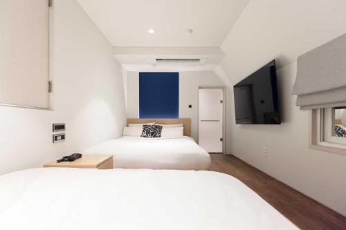 a bedroom with two beds and a tv at Ondo Hotel and Spa Jongno by Aank in Seoul