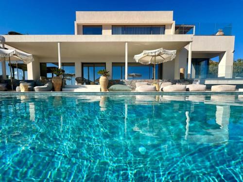 a large swimming pool in front of a house at Maison Meltem in Agia Pelagia