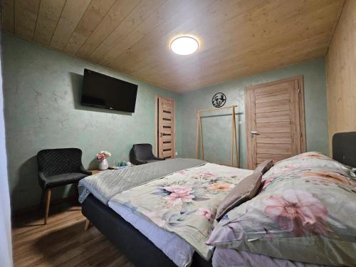 a bedroom with a bed and a tv on the wall at Wellness Toliar Tatry in Stará Lesná