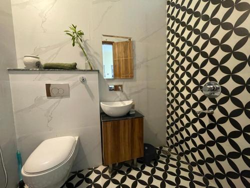 ein Badezimmer mit Toilette und Waschbecken in der Unterkunft Jon Snow's Landing in Sohāna