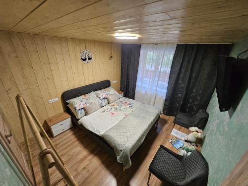 a small bedroom with a bed and a chair at Wellness Toliar Tatry in Stará Lesná