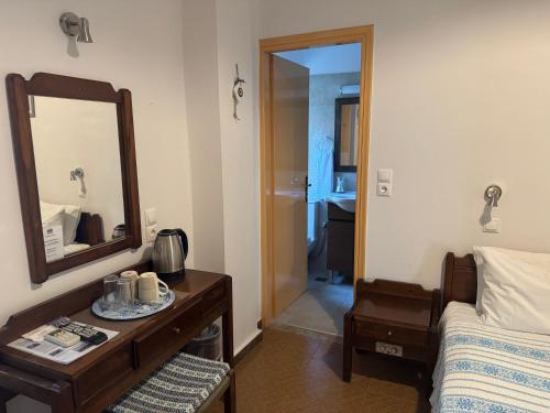 a bedroom with a bed and a mirror and a table at Pythaïs Hotel in Pythagoreio
