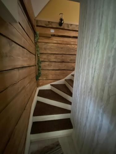 a staircase in a house with a wooden wall at Metsanõmme puhkemaja in Lümati