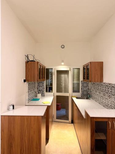 a kitchen with white counter tops and wooden cabinets at Hibiscus By Tara Suites in Jāmb