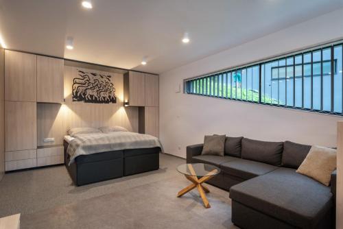 a living room with a couch and a bed at A2 Apartment & Studio - Hrabovo, Ružomberok in Ružomberok